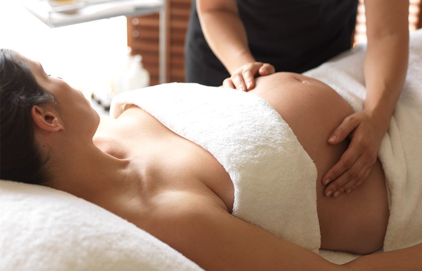 A pregnant woman enjoying an Aromatherapy Associates ultimate rose pregnancy massage